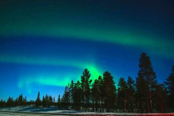 Northern lights over snowy landscape in Lapland, Finland