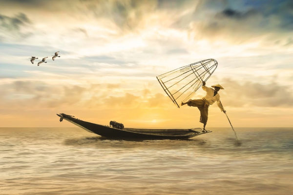 Balancing fisherman on boat in southeast asia