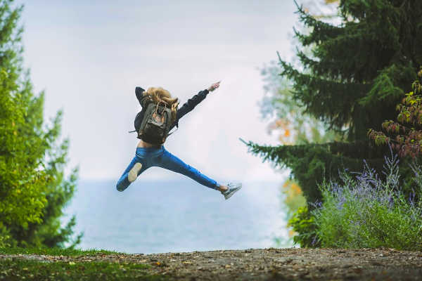 Young adventurous traveler jumping in the air