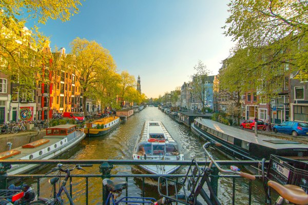 Canal of Amsterdam with river cruise and bikes