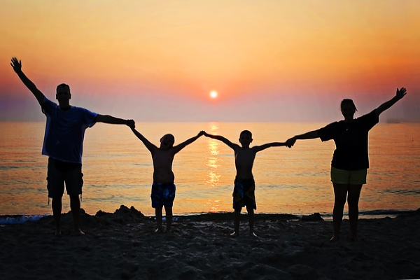 silhouette of family holding hands in the sunset