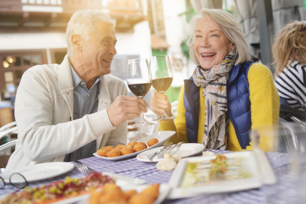 Happy older couple enjoying glass of wine while traveling