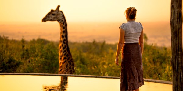 Girl and giraffe luxury safari 