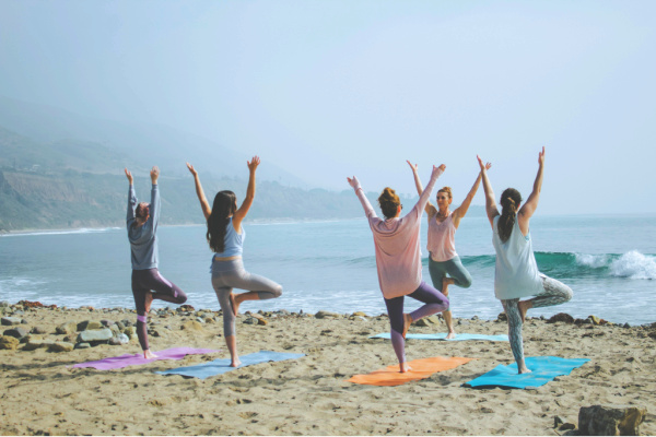 Group of people in yoga class on a beach