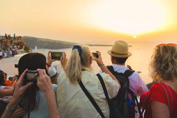 Large group of travelers photographing sunset in Europe