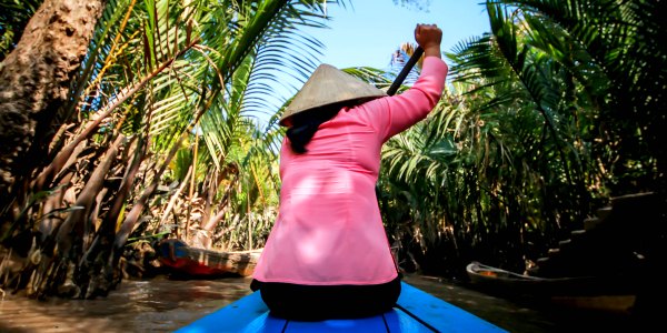Woman rowing small boat on the Mekong