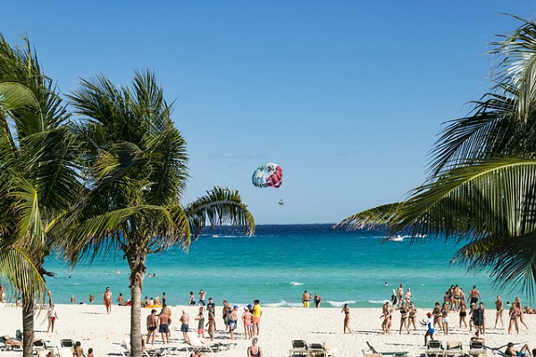 people on a beach in Cancun on a sunny day wearing bathing suits