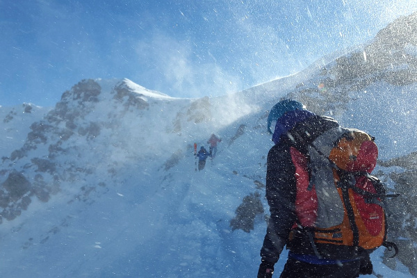 man climbing through the mountain during a snowstorm 