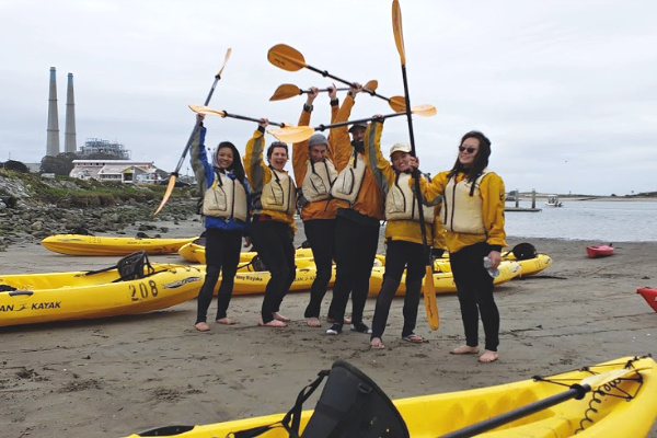 a group of people with kayak oars above their head cheering