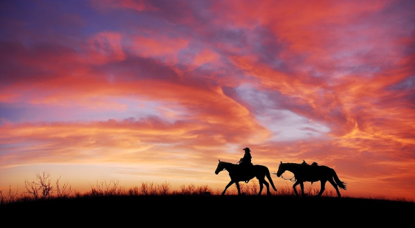 Cowboy on horseback against sunset