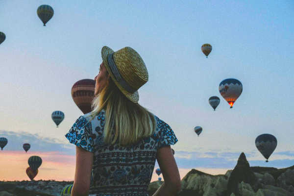 Young woman looking at hot air balloons in Turkey