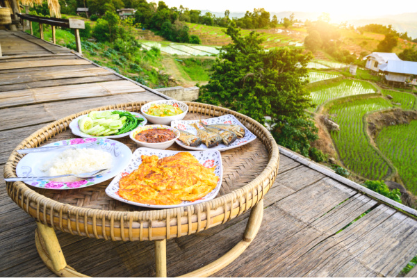 Traditional indian meal on deck overlooking rice paddies