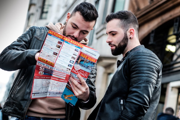 two guys looking at a map infront of a building