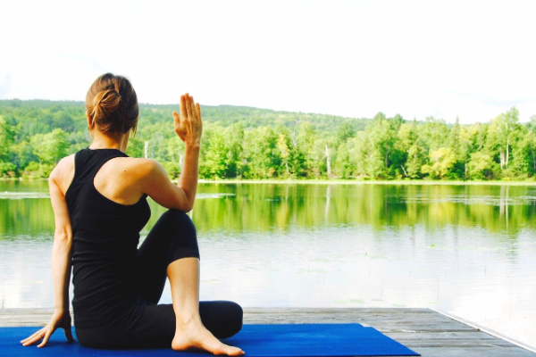 Solo person doing yoga by a lake