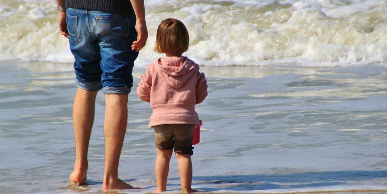 Father and young daughter on a beach