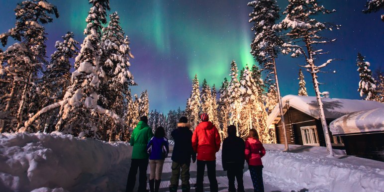 Family traveling in the arctic viewing the northern lights