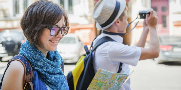 Young couple with map and camera traveling in Europe